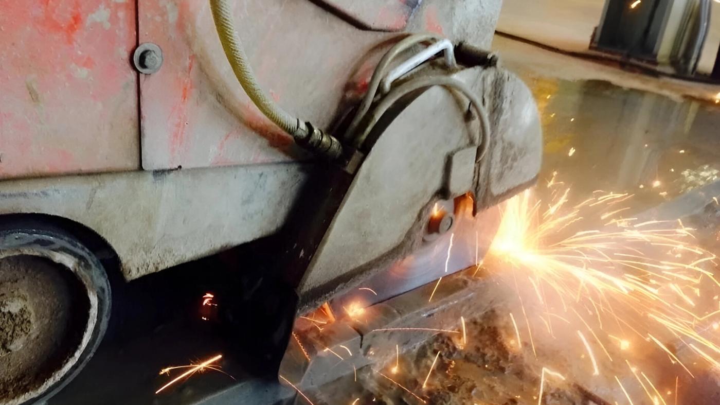 Concrete cutting with sparks on a job site